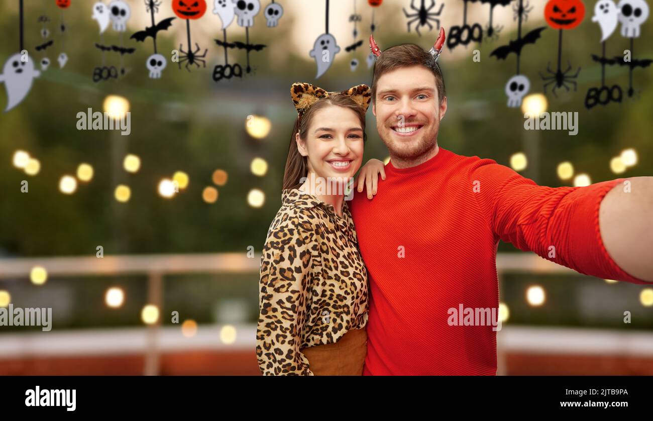 Glückliches Paar in halloween-Kostümen, das Selfie macht Stockfoto