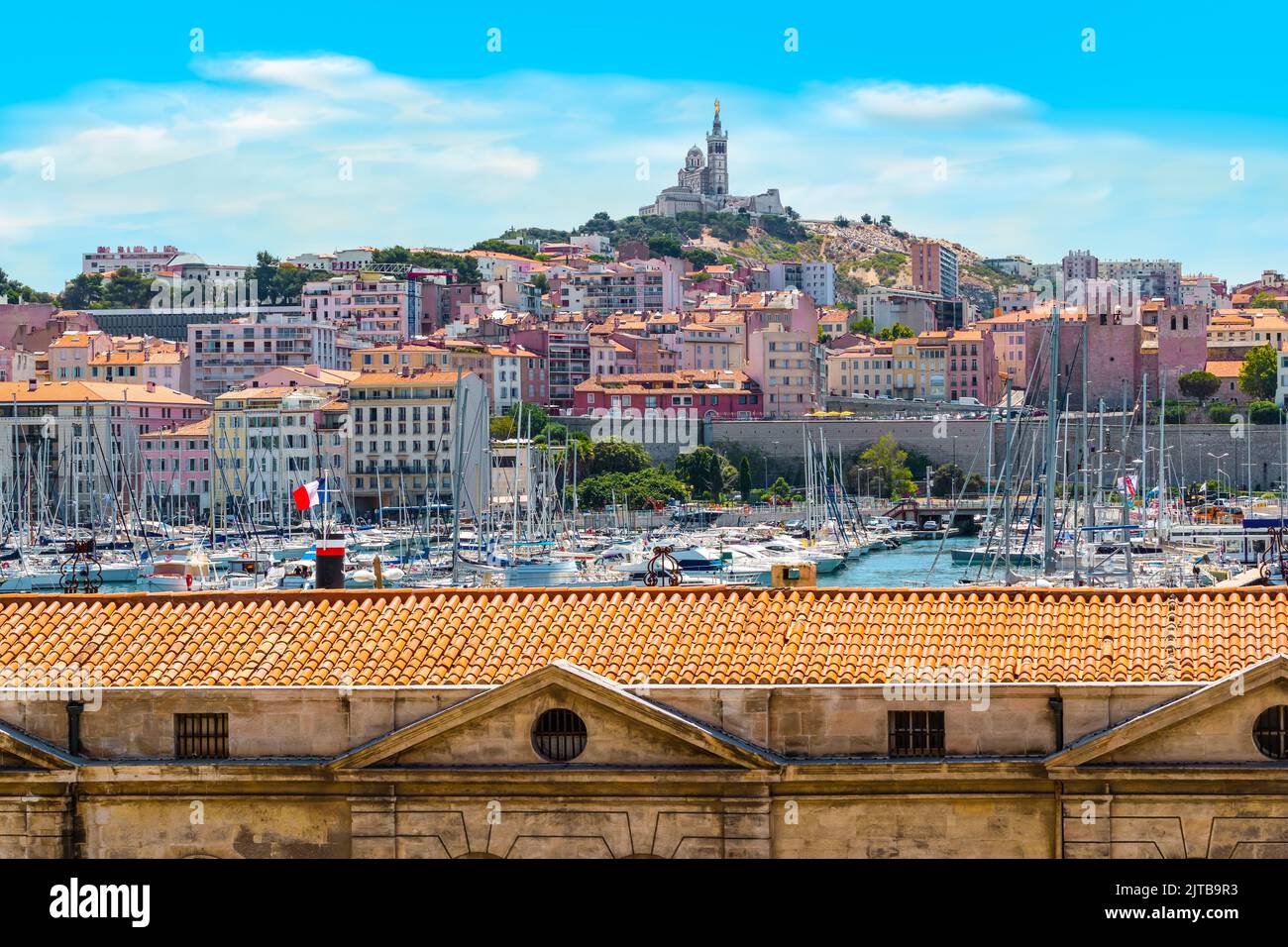 Marseille Alter Hafen mit Blick auf die berühmte Basilika Notre Dame auf dem Hügel. Stockfoto