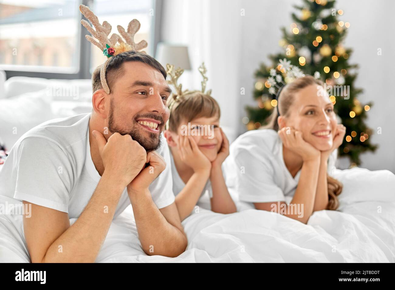 Familie im Bett am weihnachtsmorgen Stockfoto