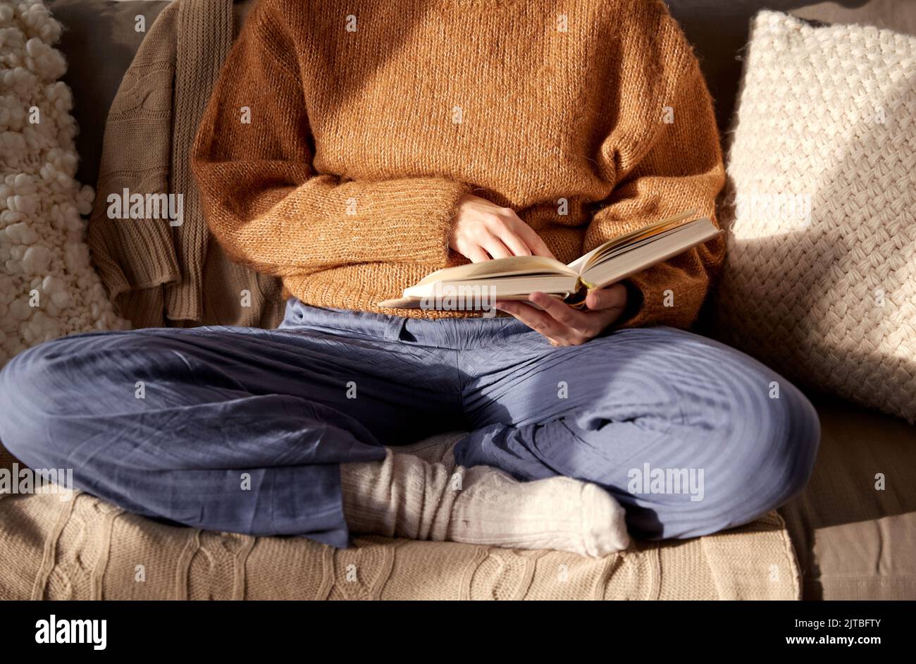Frau in warmen Pullover Buch zu Hause lesen Stockfoto