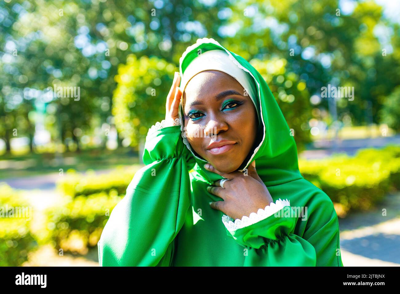 Schöne moderne Studentin in Hijab mit Make-up und Piercing Ring auf der Nase draußen Stockfoto