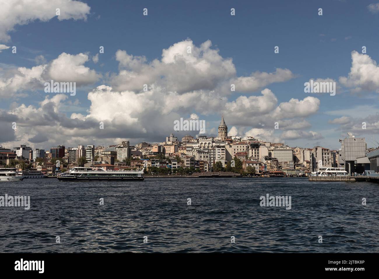 Blick auf die Ausflugsboote am Goldenen Horn von Bosporus in Istanbul. Im Hintergrund befinden sich der Galata-Turm und der Beyoglu-Bezirk. Es ist ein sonniger Sommertag. Stockfoto