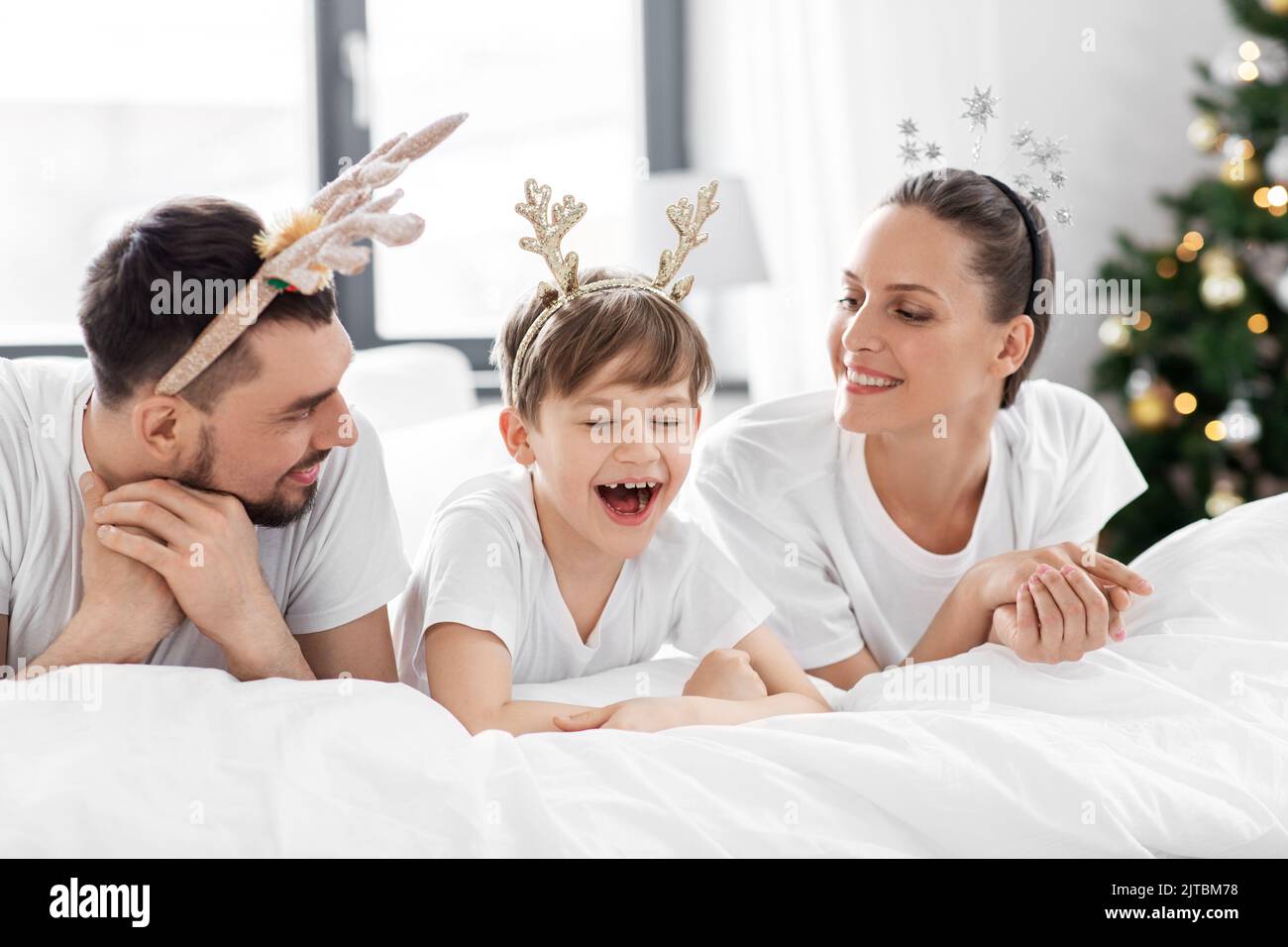 Familie im Bett am weihnachtsmorgen Stockfoto