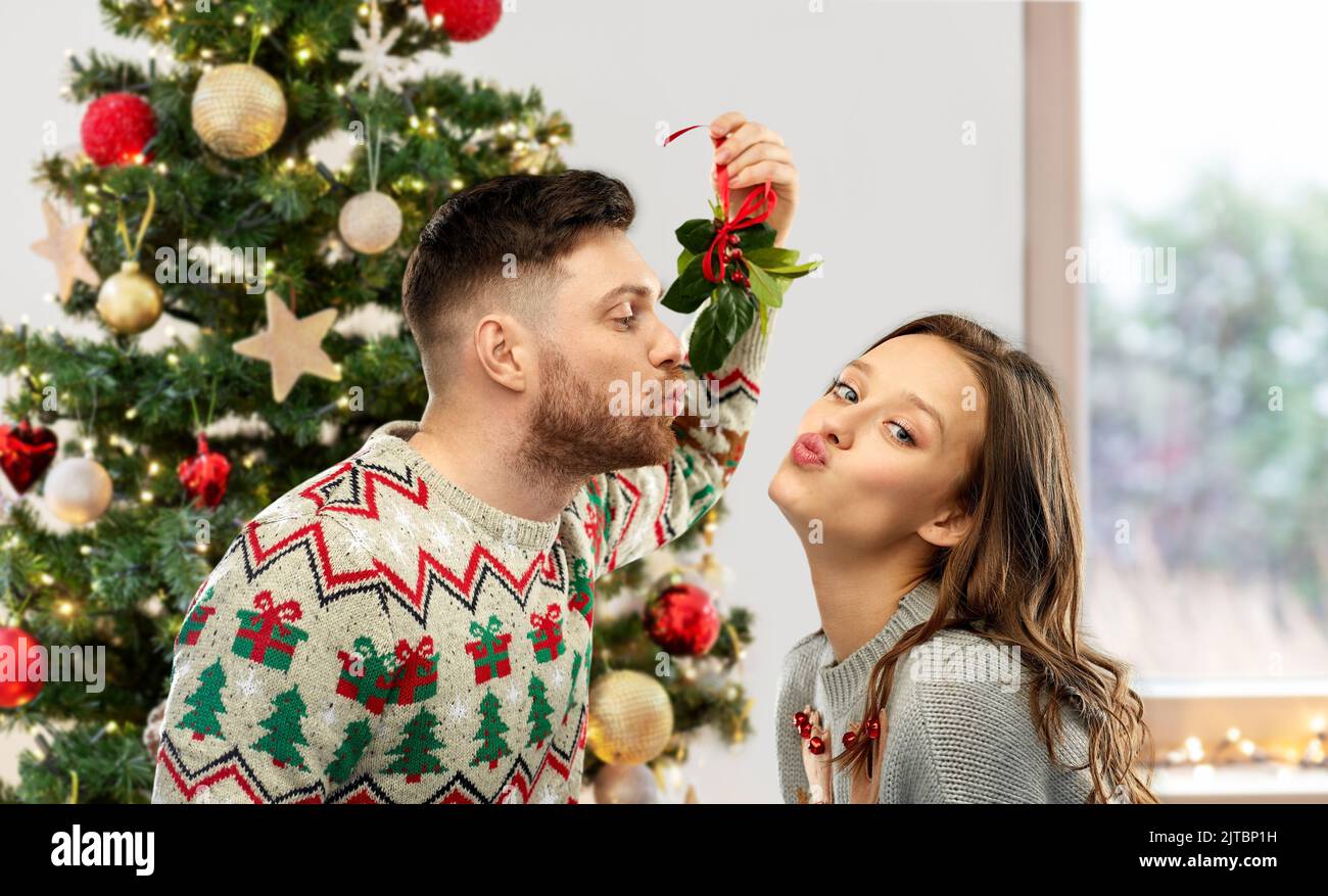 Pärchen küsst sich an weihnachten unter der Mistel Stockfoto