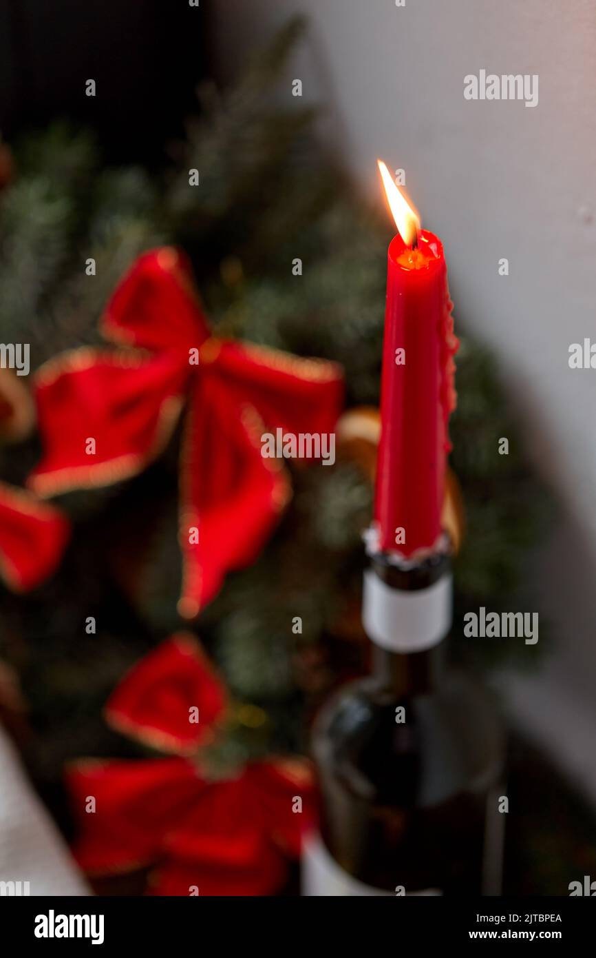 Rote weihnachtskerze brennt in Weinflasche Stockfoto