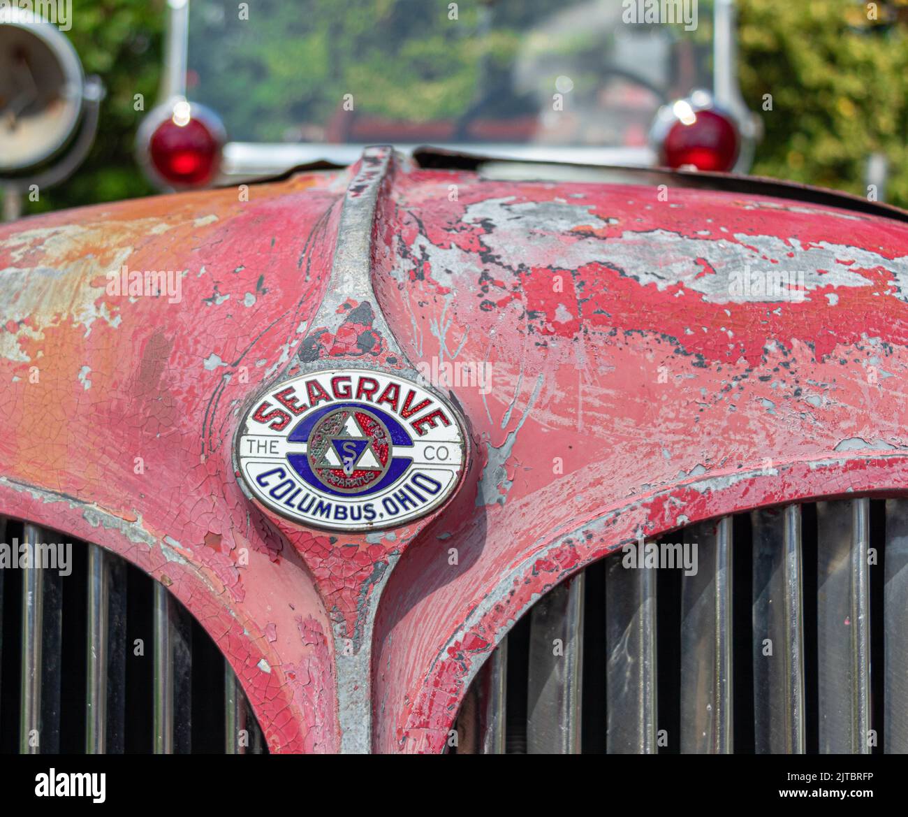 Eine Nahaufnahme eines alten roten rostigen Logos eines Oldtimers aus Metall Stockfoto