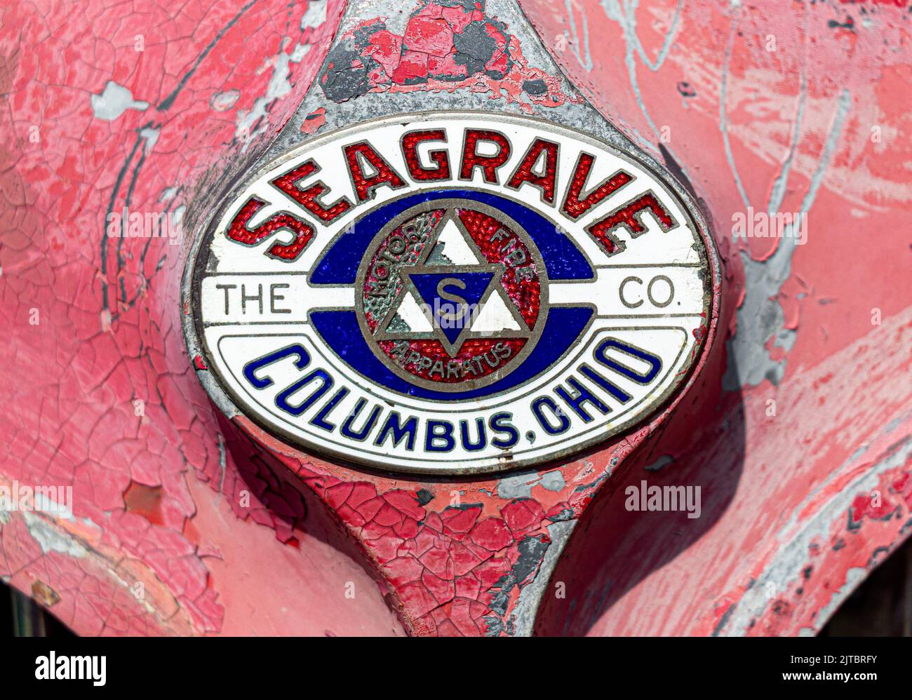 Eine Nahaufnahme eines alten roten rostigen Logos eines Oldtimers aus Metall Stockfoto