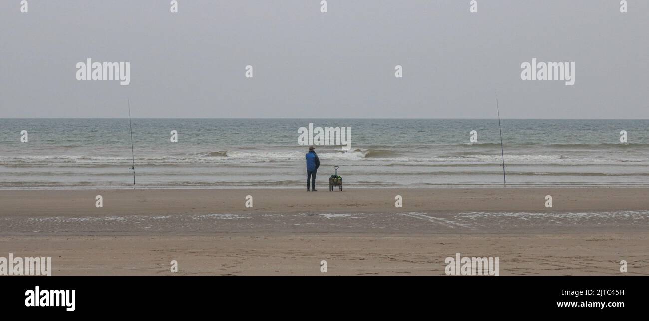 homme qui pêche face à l'océan. Mer et Plage Stockfoto