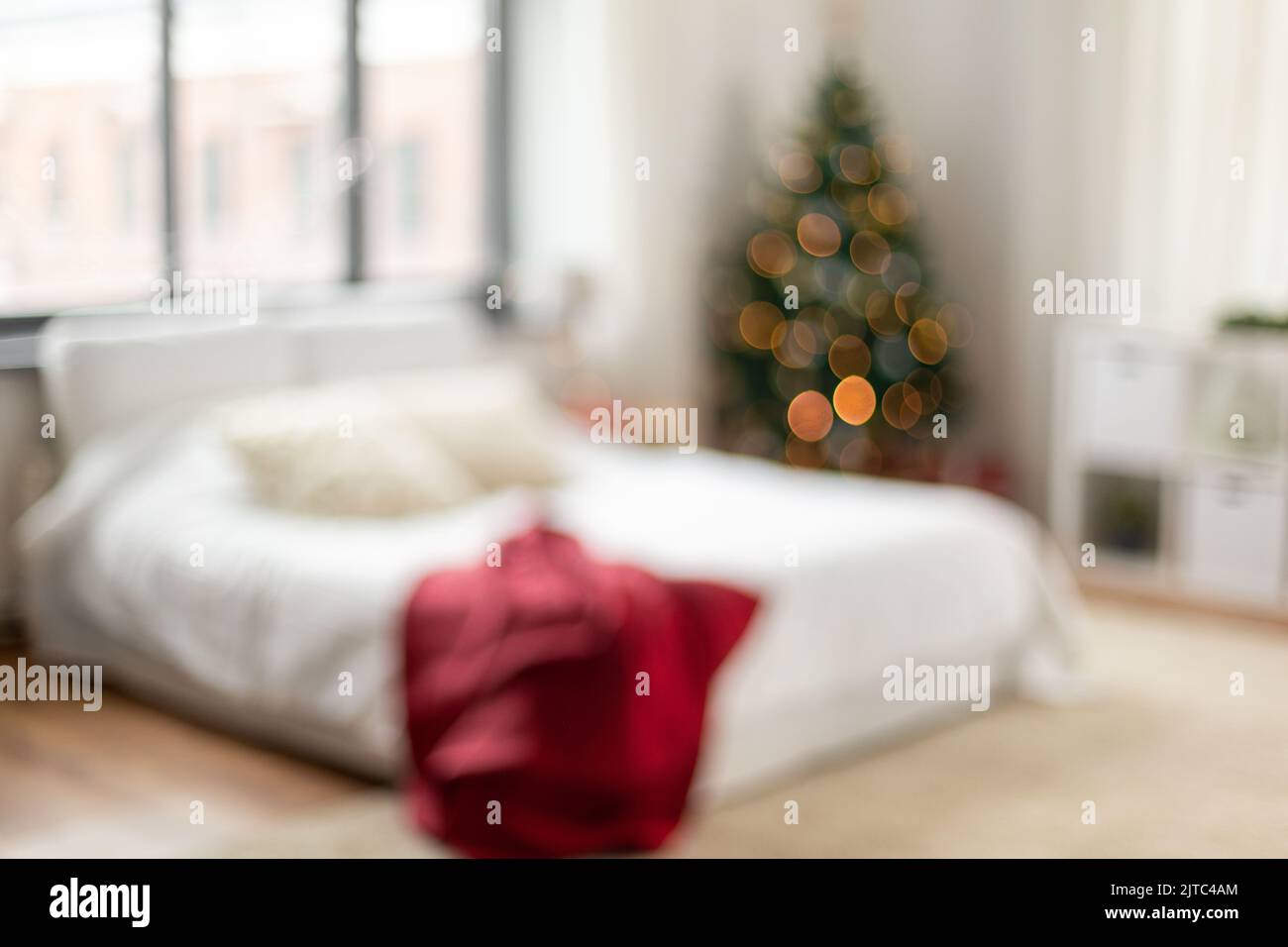 Verschwommenes Bett im Schlafzimmer im gemütlichen Zuhause an weihnachten Stockfoto