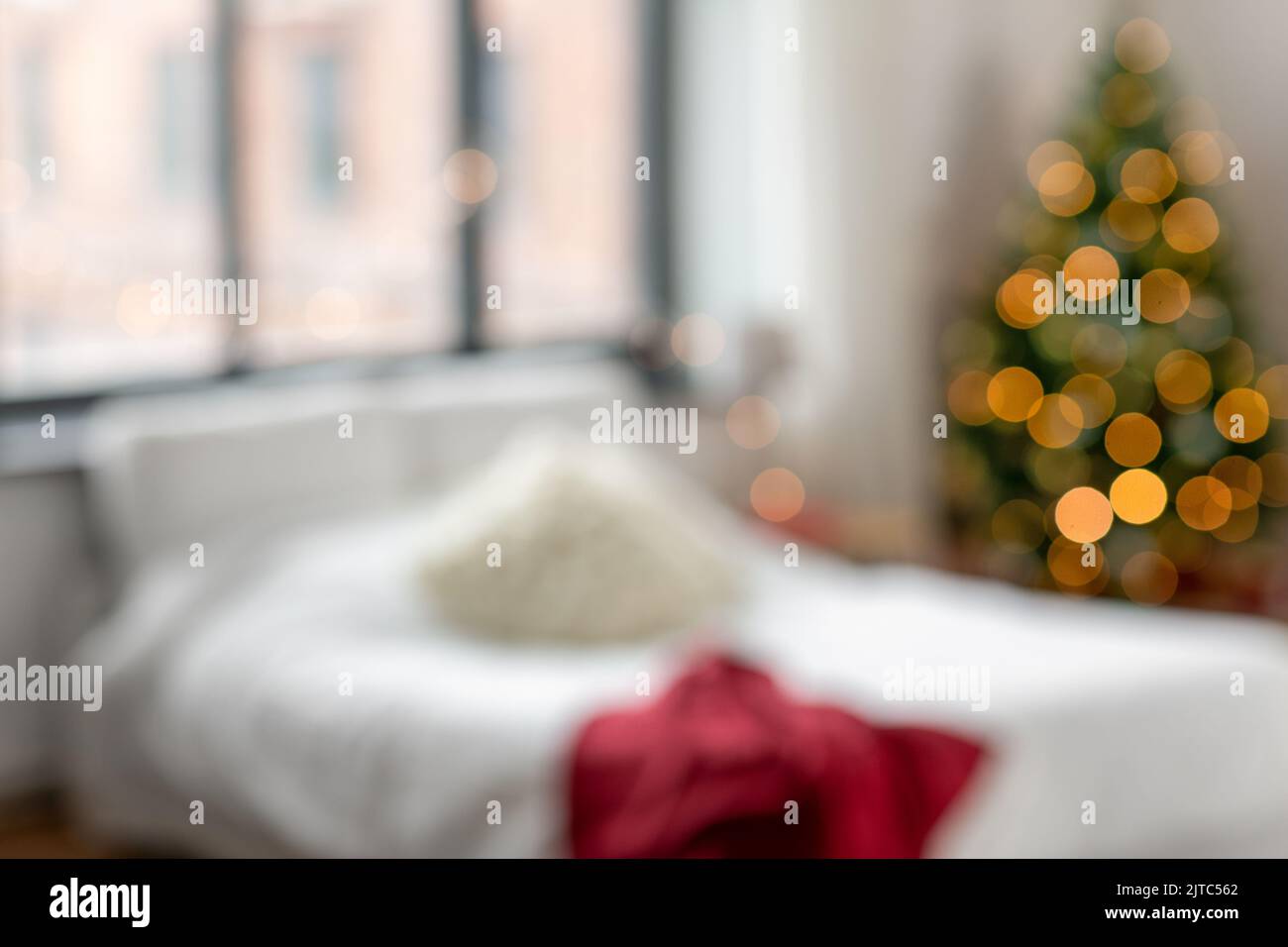 Verschwommenes Bett im Schlafzimmer im gemütlichen Zuhause an weihnachten Stockfoto