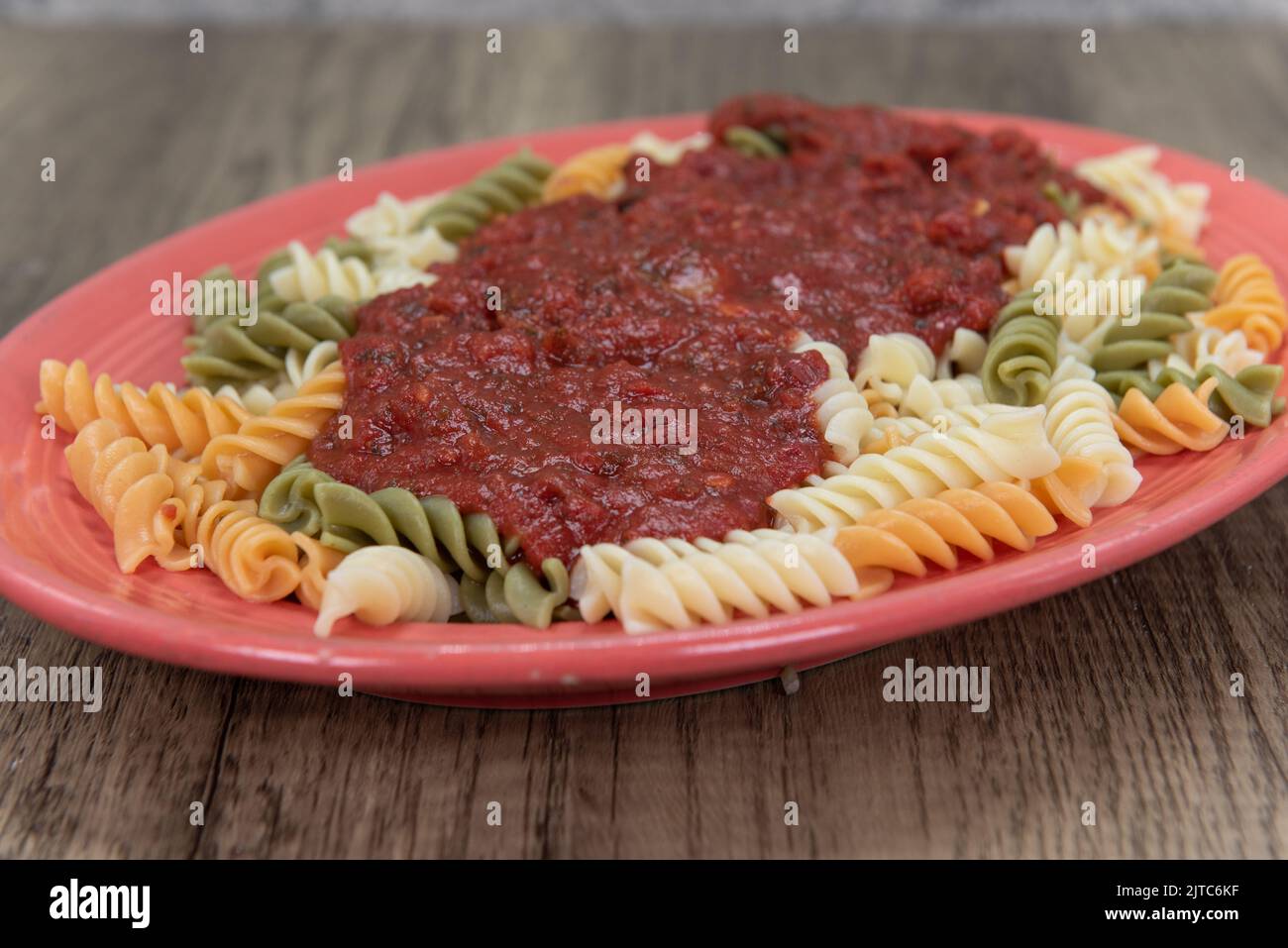 Rotelli Pasta in authentischer italienischer Marinara-Sauce erstickt und großzügig auf einem ovalen Teller serviert. Stockfoto