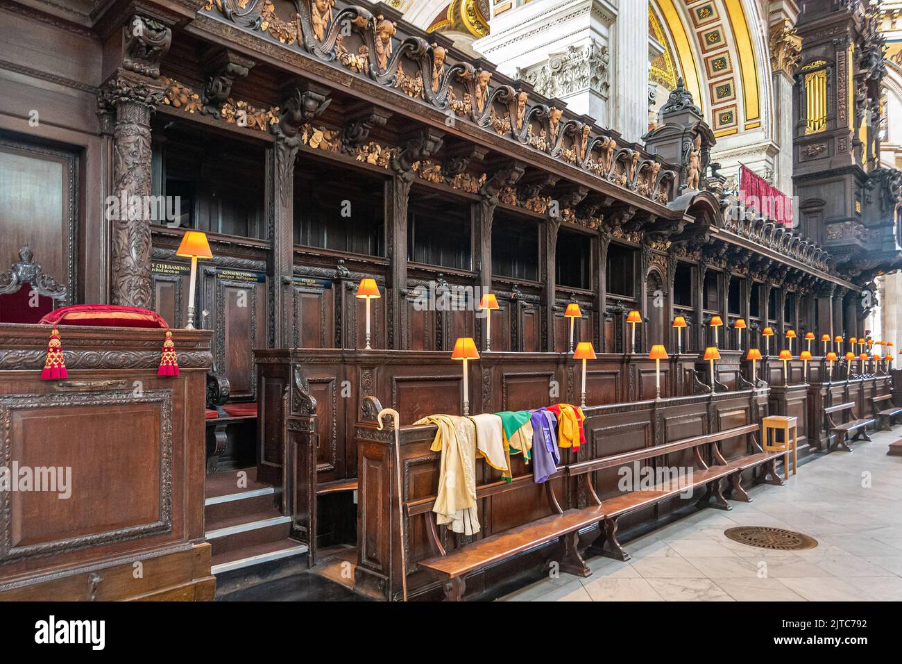 London, England, Großbritannien - 6. Juli 2022: St. Paul's Cathedral. Dunkle hölzerne, hoch dekorierte Kirchenchor VIP Bänke. Orangefarbene Lichter, bunte Textilien und Stockfoto