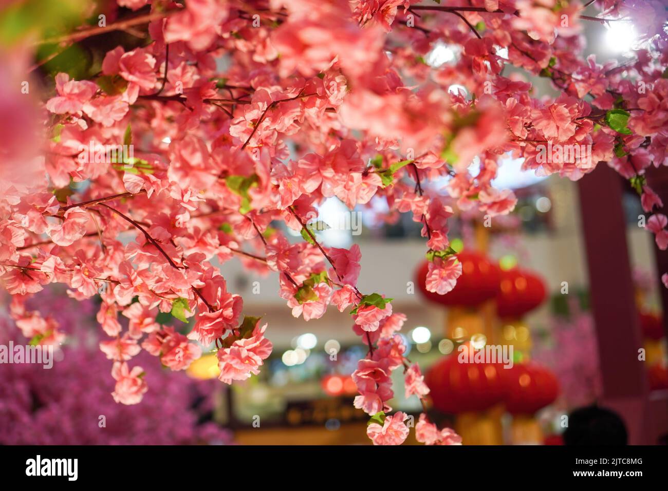 Eine Nahaufnahme einer gefälschten Pflaumenblüte, die als chinesische Neujahrsdekoration an der Decke hängt Stockfoto