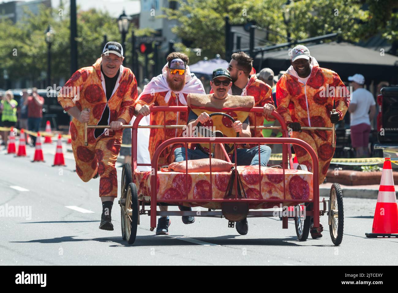 LAWRENCEVILLE, GA / USA - 23. APRIL: Männer in Pepperoni-Pizza-Kostümen schieben am 23. April 2022 in Lawrenceville, GA, ein Bett in einem Charity-Bett-Rennen. Stockfoto