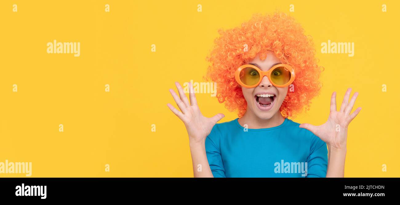 Happy teen Mädchen in fancy Clown Perücke tragen lustige Party-Brille, Überraschung. Lustige Teenager Kind in Perücke, Party-Poster. Banner-Kopfzeile, Kopierbereich. Stockfoto