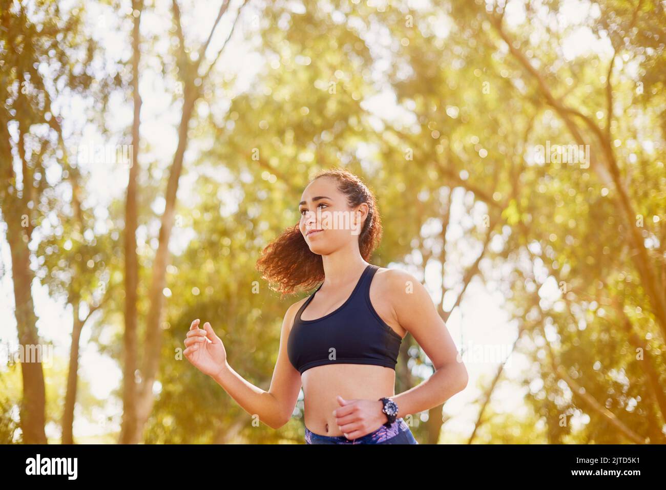 Laufen Sie jetzt und Sie fühlen sich den ganzen Tag gut. Eine sportliche junge Frau auf einen Lauf in der Natur. Stockfoto