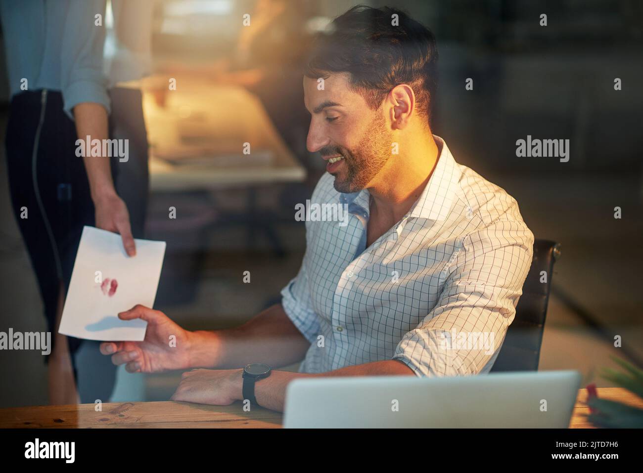 Nur für Ihre Augen. Ein gutaussehender Geschäftsmann, der eine Liebesnote von einer Kollegin bei der Arbeit erhält. Stockfoto