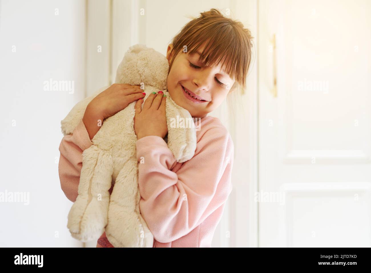 Ich liebe meine liebste kleine Freundin. Ein entzückendes kleines Mädchen umarmt ihren Teddybär. Stockfoto