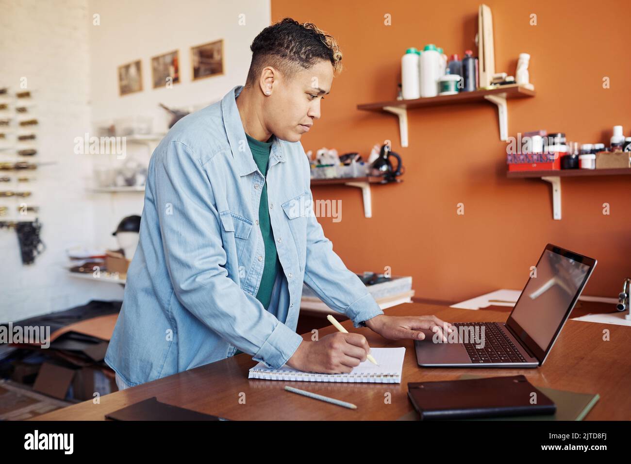 Seitenansicht Porträt einer modernen Frau, die einen Laptop verwendet, während sie die Fertigung kleiner Unternehmen verwaltet, Kopierfläche Stockfoto