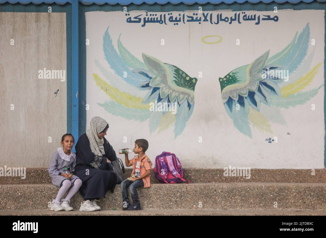 Gaza-Stadt, Palästina. 29. August 2022. Eine palästinensische Mutter sitzt mit ihren Kindern am ersten Tag des persönlichen Unterrichts an einer öffentlichen Schule in Gaza-Stadt. Das palästinensische Bildungsministerium sagte, dass 1.385.000 Schüler das neue Schuljahr im Osten begonnen haben. Jerusalem, das Westjordanland und der Gazastreifen umfassen 3.192 Schulen, die auf 2.333 öffentliche Schulen verteilt sind, 375 Schulen, die vom Hilfswerk der Vereinten Nationen für Palästina-Flüchtlinge (UNRWA) betrieben werden, und 484 private Schulen. (Foto von Mahmoud Issa/SOPA Images/Sipa USA) Quelle: SIPA USA/Alamy Live News Stockfoto