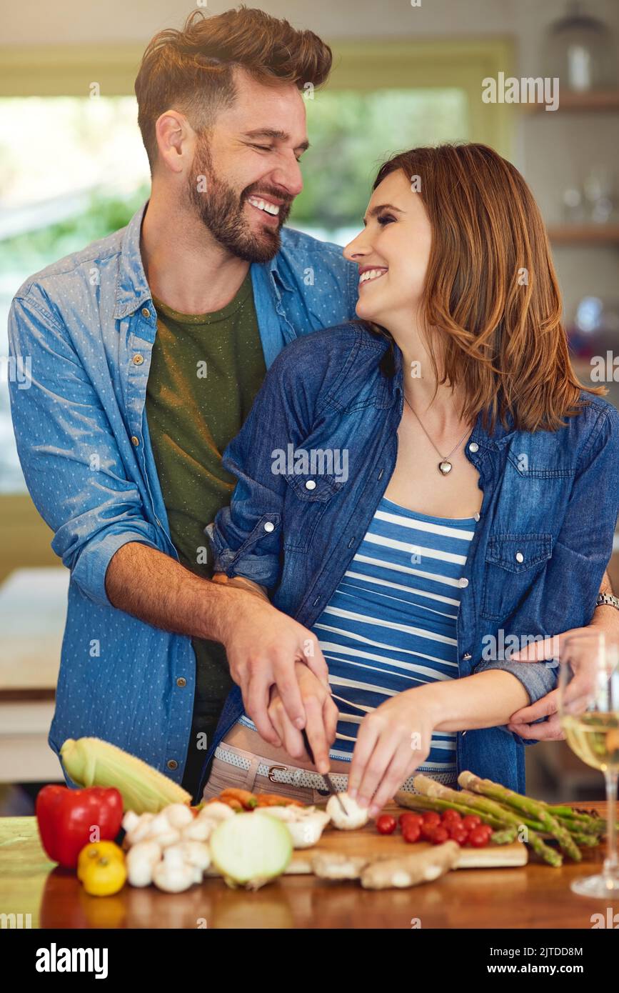 Köstliche und nahrhafte Küche für das gesundheitsbewusste Paar. Ein glückliches junges Paar bereitet zu Hause gemeinsam eine gesunde Mahlzeit zu. Stockfoto