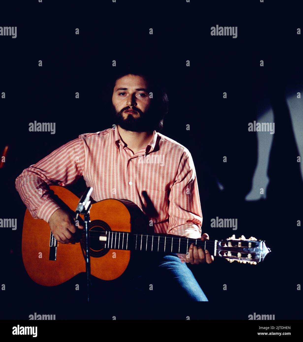 Amedeo Minghi, italienischer Liedermacher, ein Cantautore, Portrait mit Gitarre, Deutschland, Ca. 1976. Amedeo Minghi, italienischer Sänger und Songwriter, ein Cantautore, Porträt mit Gitarre, Deutschland, um 1976. Stockfoto