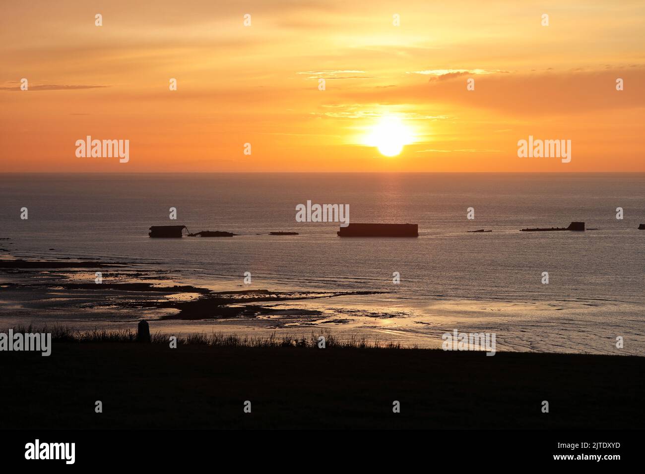 Sonnenuntergang über den Überresten des Mulberry Harbour von WW2 am Gold Beach, Arromanches-les-Bains, Normandie, Frankreich. Stockfoto