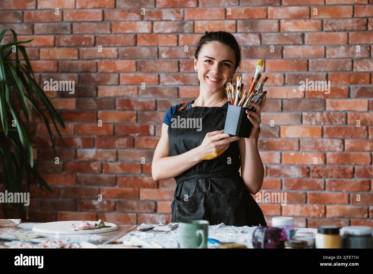 Werkzeuge Kunsttalent Frau Maler Arbeitsplatz lächelnd Stockfoto