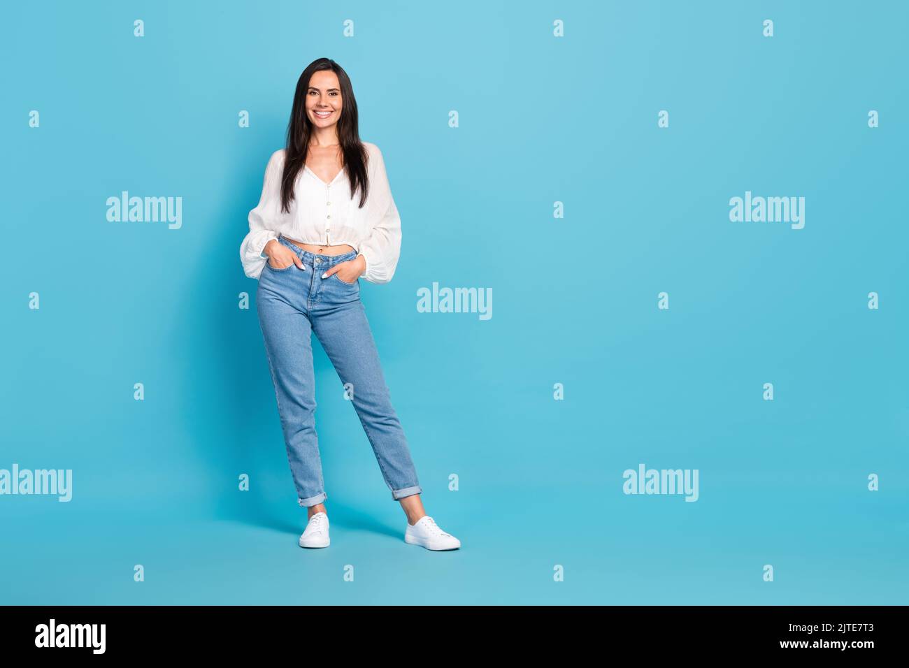 In voller Größe Foto von atemberaubenden zufrieden Mädchen legte Hände Taschen posiert leeren Raum auf blauem Hintergrund isoliert Stockfoto