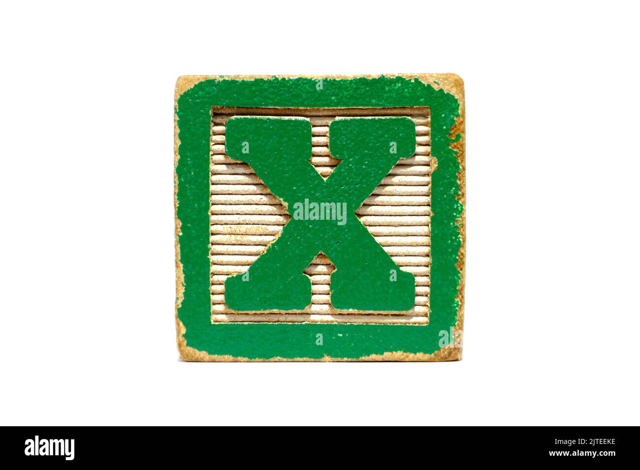 Verzweifelter Vintage-Spielzeugblock in Grün und Weiß, fotografiert vor weißem Hintergrund. Der Buchstabe X. Erziehungswerkzeug oder Spielzeug für Kinder Stockfoto