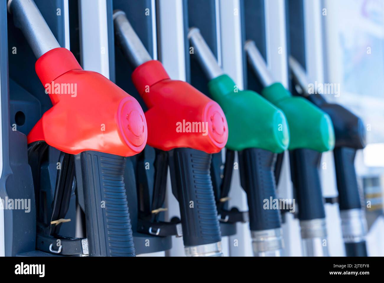 Tankpistolen hängen in einer Reihe an einer Tankstelle. Seitenansicht von unten Stockfoto