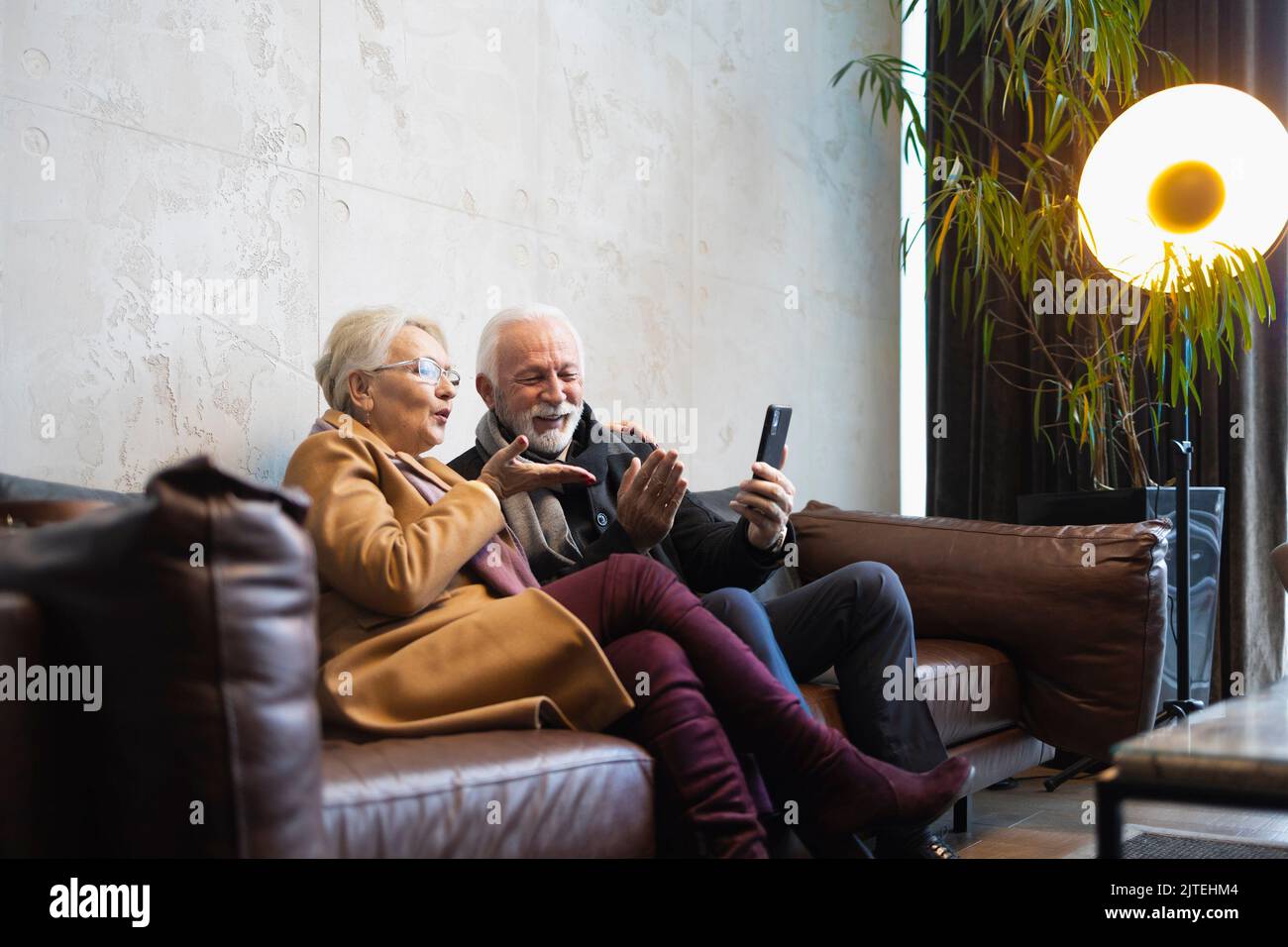 Ältere Paare, die ihren Angehörigen per Videoanruf Küsse schicken Stockfoto