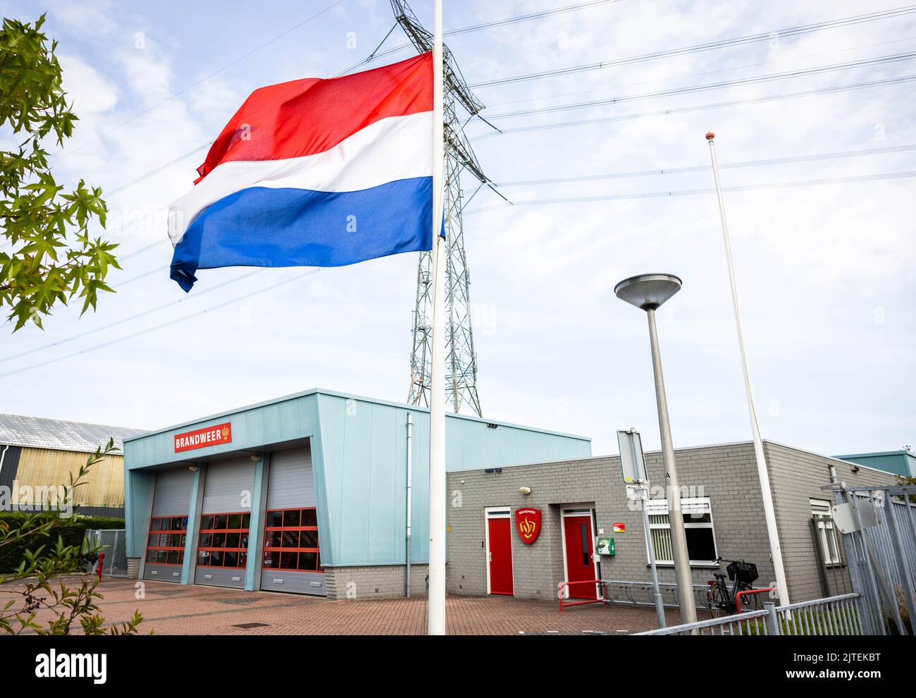 2022-08-30 12:32:22 NEW BEIJERLAND - Flaggen hängen am halben Mast in Erinnerung an die Opfer des tödlichen Unfalls. Am Samstag fuhr ein LKW vom Deich in Nieuw-Beijerland und traf die Anwesenden bei einer Nachbarschaftsfeier. Zusätzlich zu den sieben Verletzten wurden sechs Menschen getötet. ANP JEFFREY GROENEWEG niederlande Out - belgien Out Stockfoto