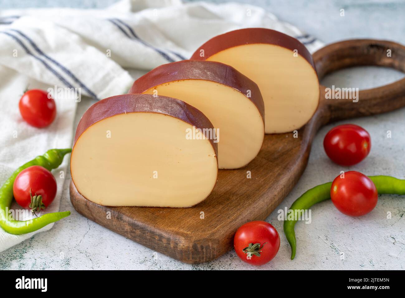 Geräucherter Käse. Holländischer geräucherter Käse auf Steinhintergrund. Nahaufnahme Stockfoto