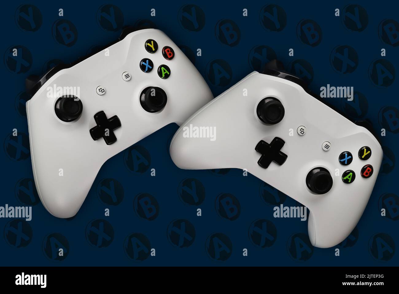 Zwei Spielkonsolen im Flug auf dunkelblauem Hintergrund mit Knöpfen für Spiele Stockfoto
