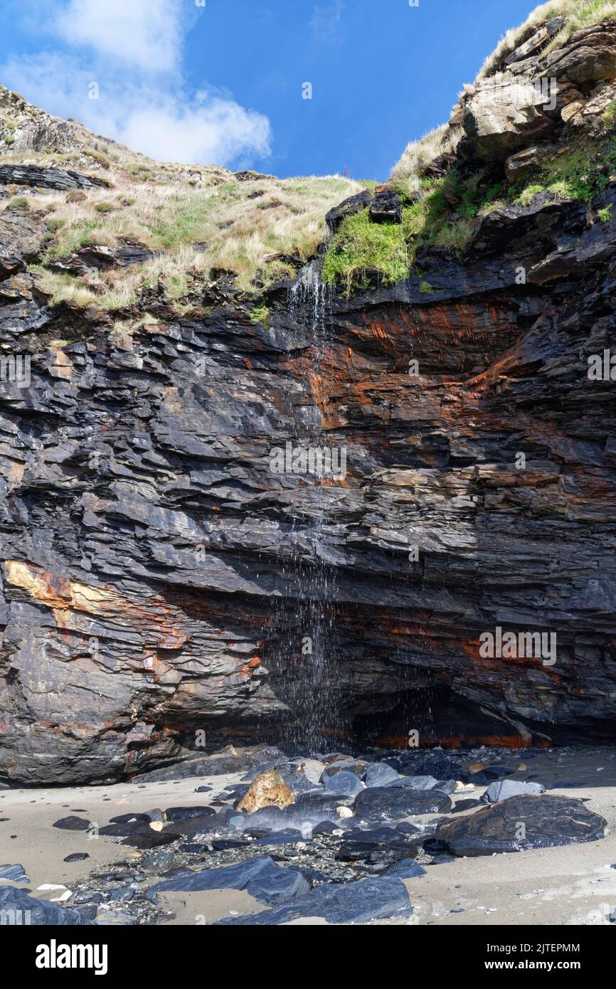 Kleiner Wasserfall, der eine Klippe hinunter fließt, Tarregock Beach, in der Nähe von Delabole, Cornwall, Großbritannien, September 2021. Stockfoto