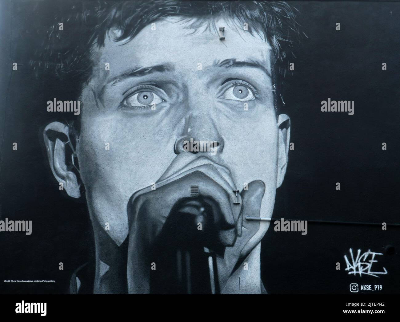 Manchester, England, 19.. Juli 2021 ein Bild von Ian Curtis, Sänger der legendären Manchester-Band Joy Division. Das Bild wurde im August 2022 mit einer Werbung für ein neues Album von einem Rap-Künstler namens „Aitch“ alias Harrison James Armstrong übermalt. Das Wandbild wurde von Akse ©GED Noonan/Alamy geschaffen Stockfoto