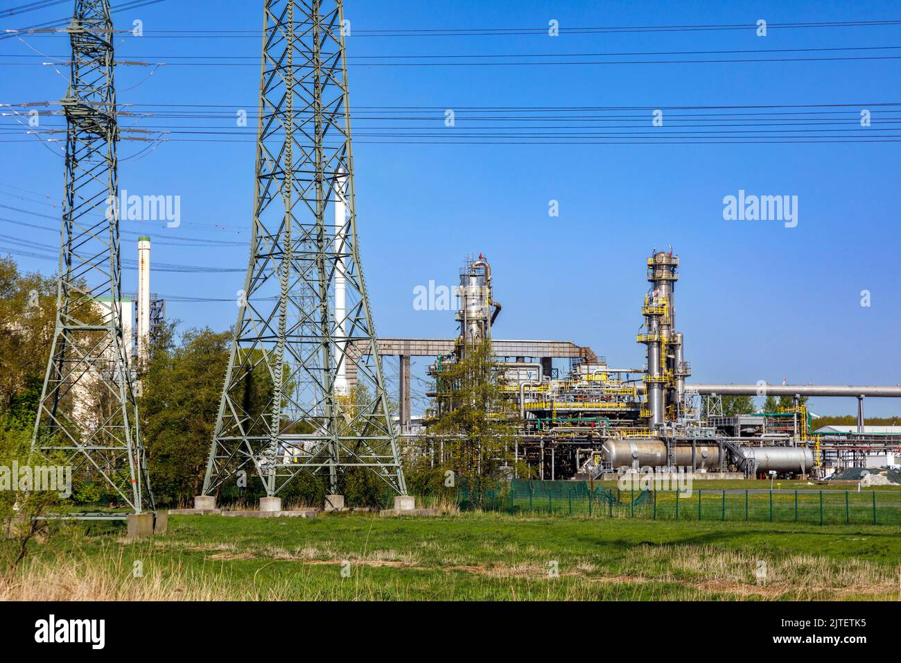 Hochspannungsleitung am Holstendamm in Brunsbüttel, TotalEnergies Bitumen Deutschland GmbH im Hintergrund Stockfoto