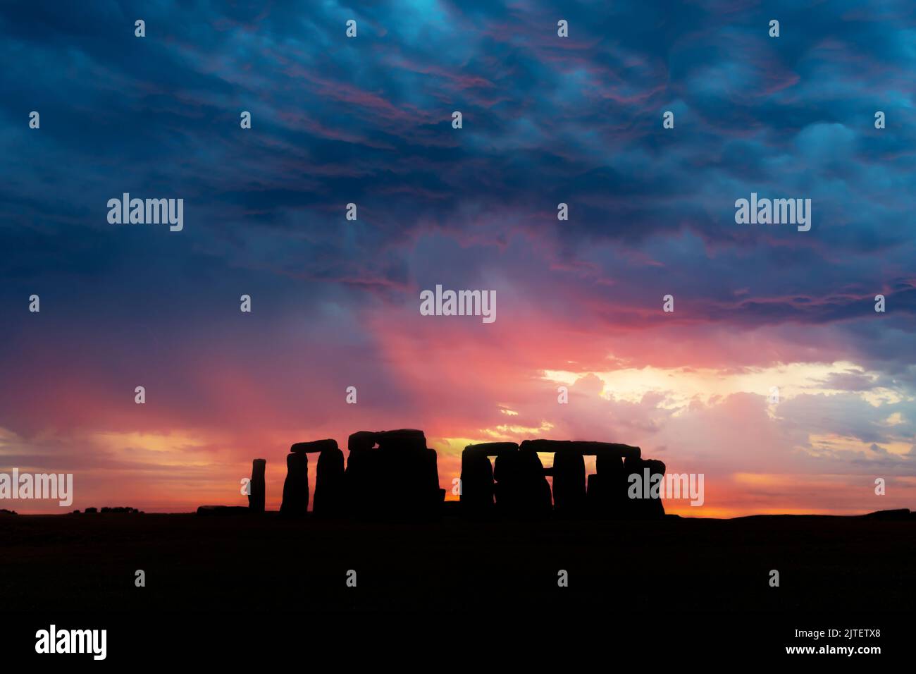 Das berühmte prähistorische Denkmal von Stonehenge mit einem dramatischen Himmel bei Sonnenuntergang, Vereinigtes Königreich Stockfoto