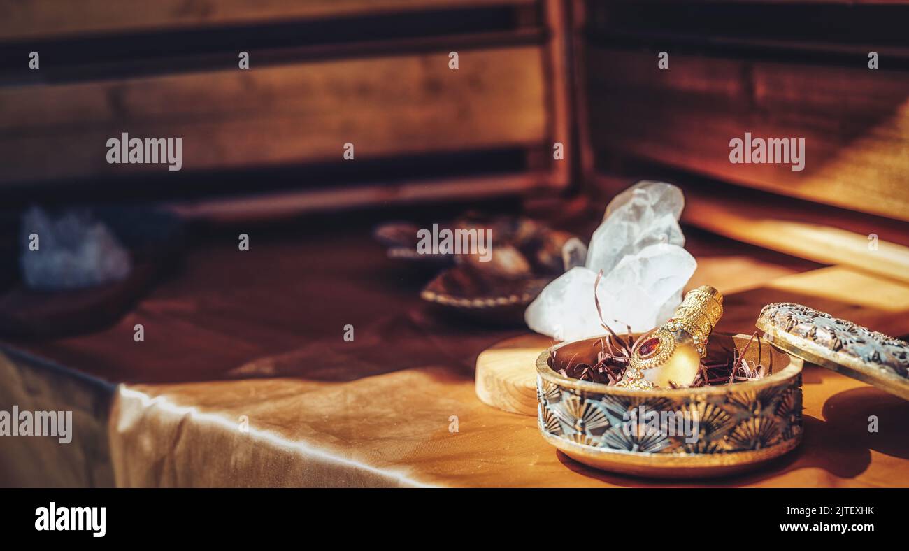 Ornamentale Flasche mit Parfüm und Kristall auf einem Holzhintergrund. Stockfoto