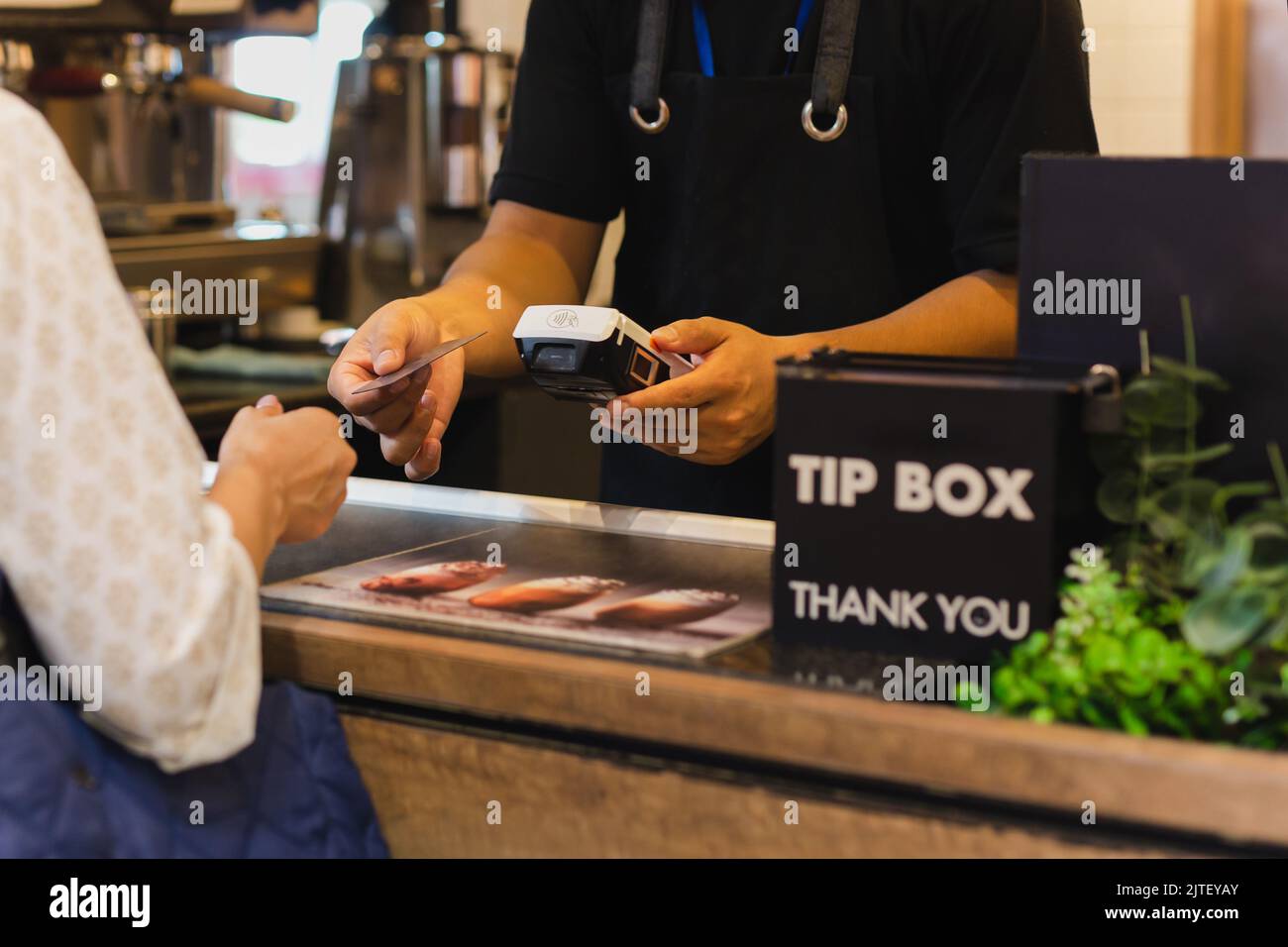 Asia Frau verwenden bargeldlosen WiFi Paywave Scan auf Kartenleser im Café. Stockfoto