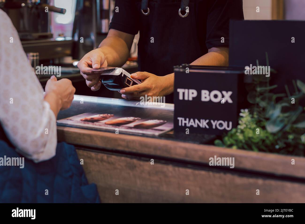 Asia Frau verwenden bargeldlosen WiFi Paywave Scan auf Kartenleser im Café. Stockfoto