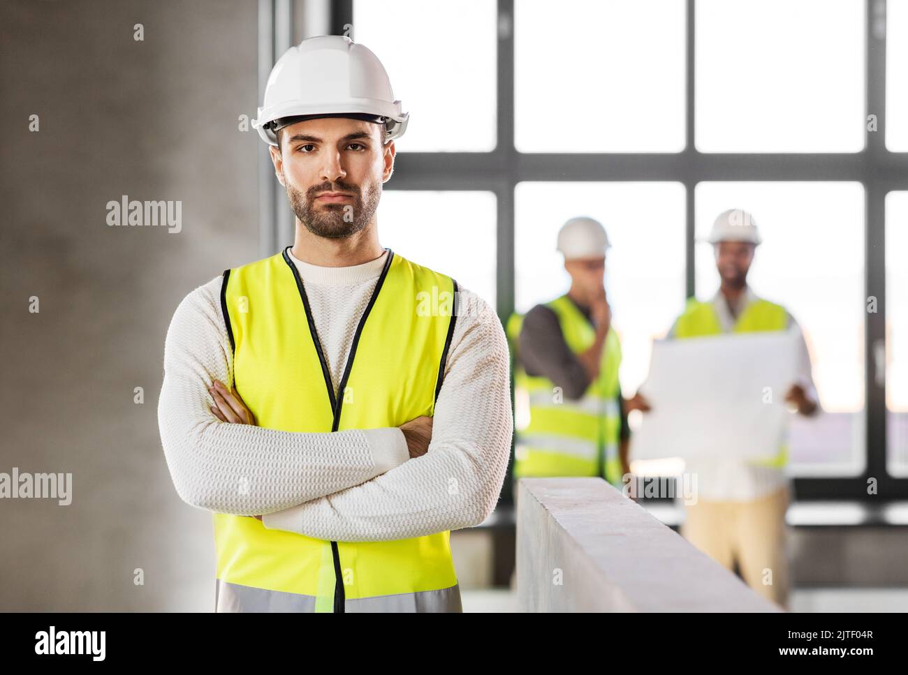 Männlicher Architekt in Helm und Sicherheit West im Büro Stockfoto