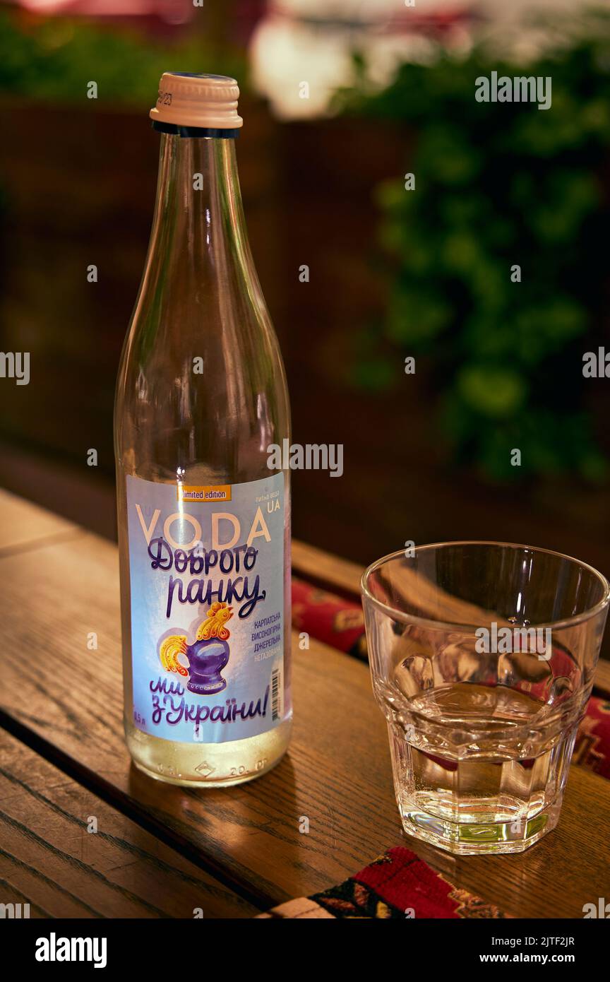 Transparente Glasflasche und ein Glas Mineralwasser auf einem Restauranttisch Stockfoto