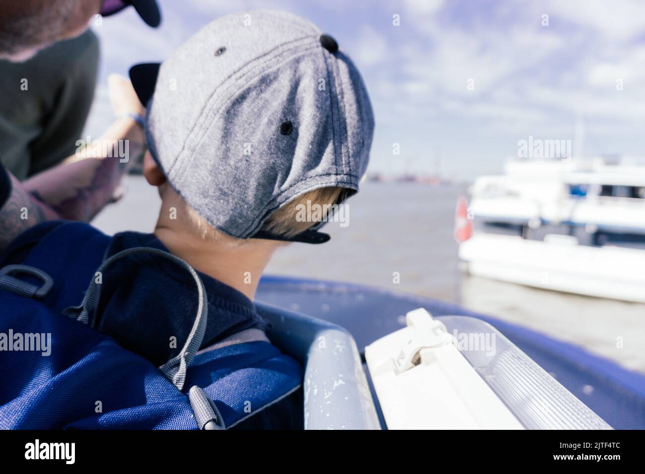 Mann, der dem Kind während der Bootsfahrt etwas am Horizont zeigt Stockfoto