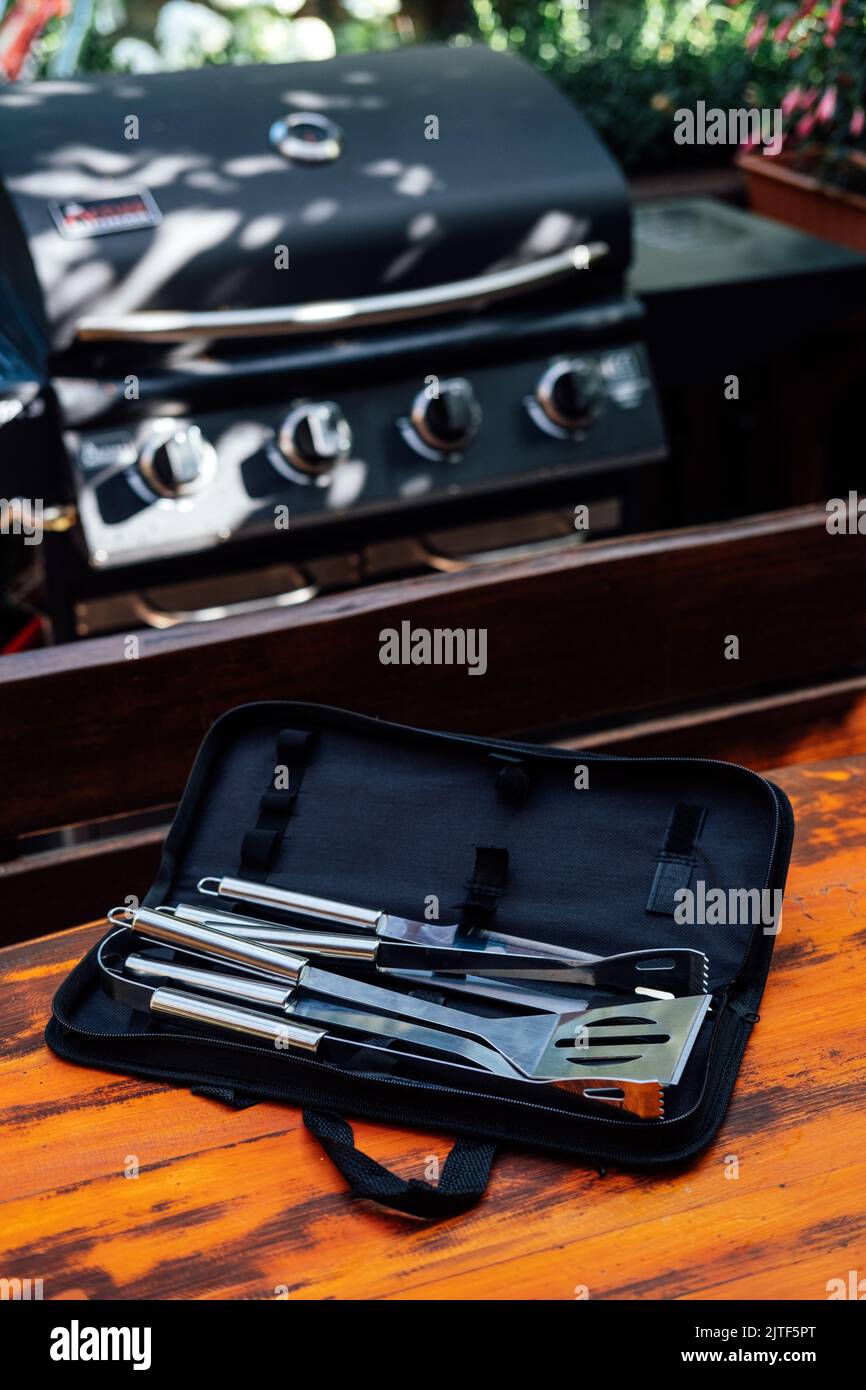 Grillwerkzeug auf Grillhintergrund eingestellt. Grillzubehör-Set, Griff Edelstahl Grillwerkzeuge-Set für Außengrill Stockfoto