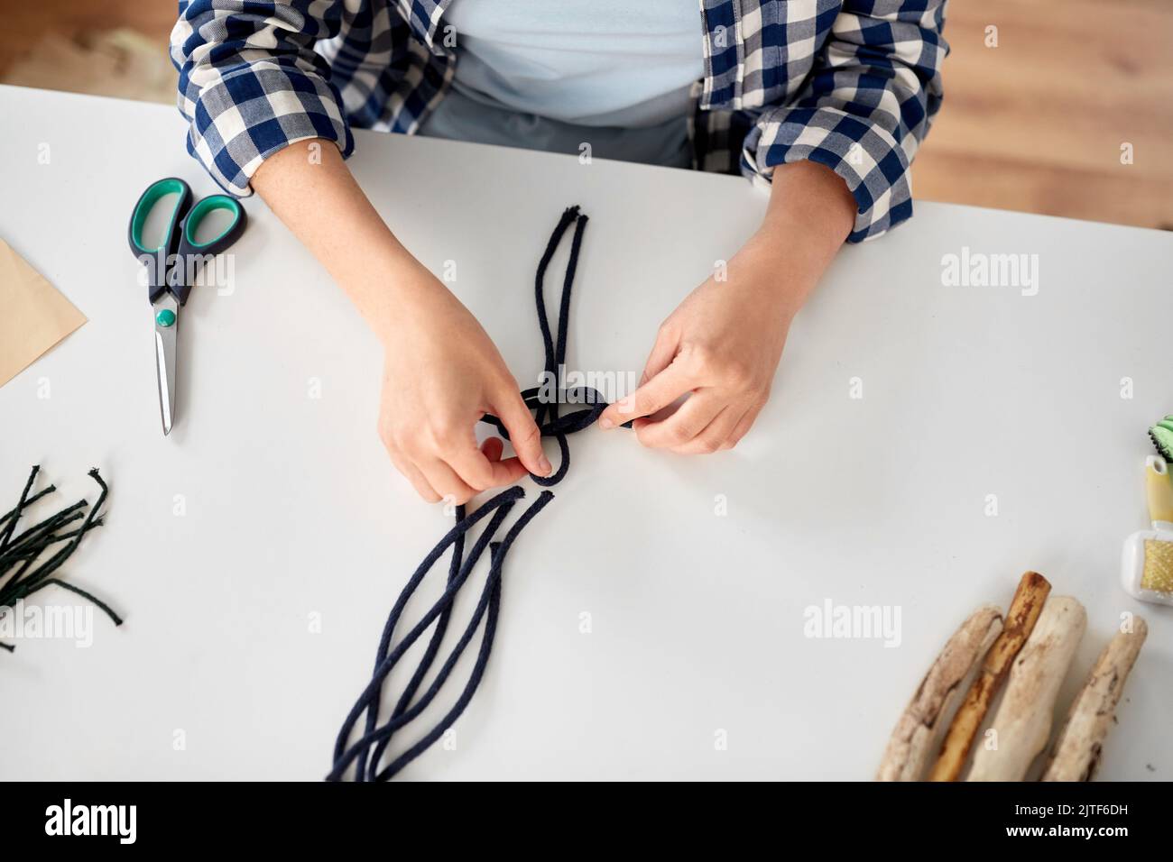 Frau, die Makrame macht und Schnüre verknotet Stockfoto