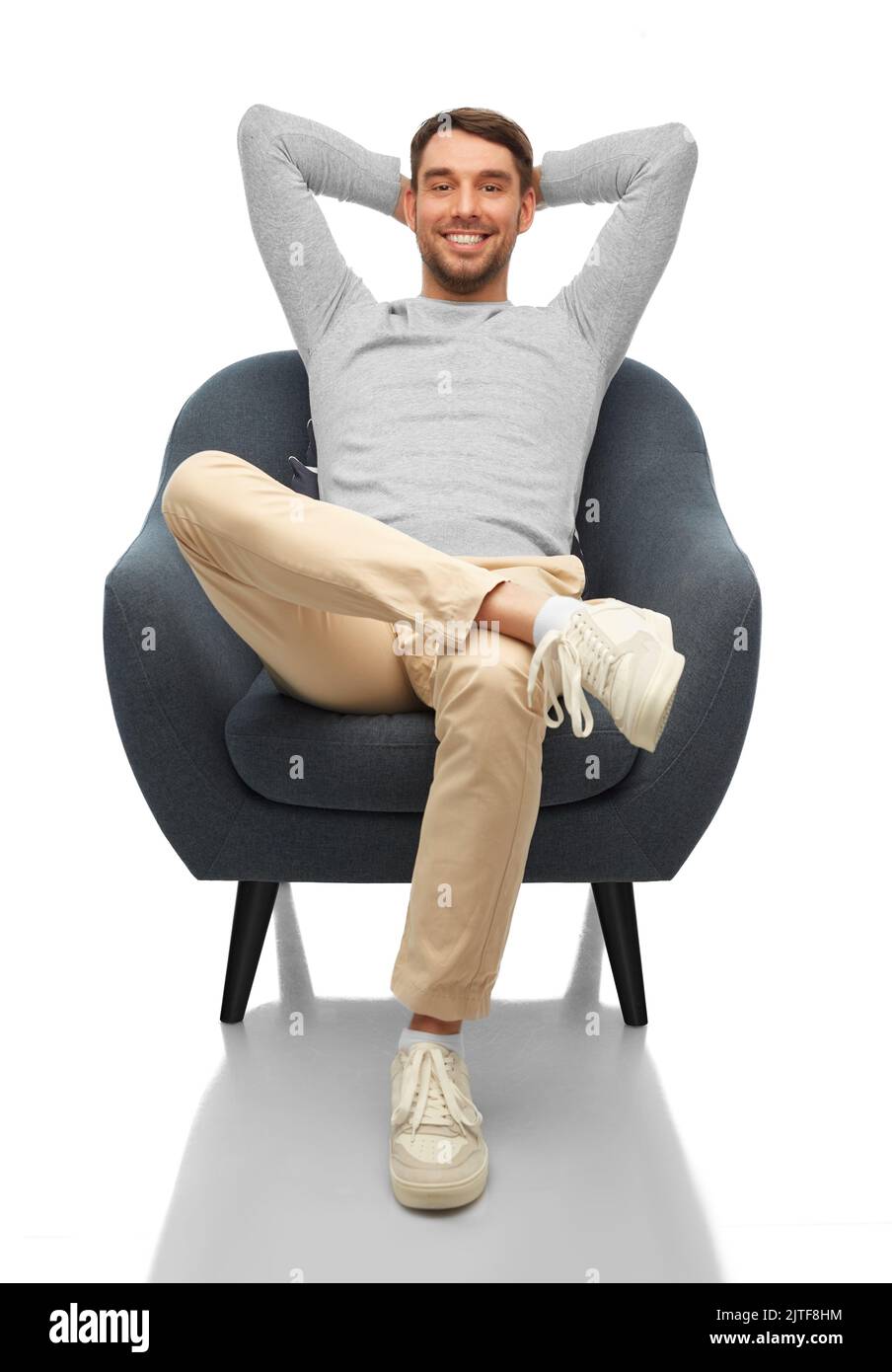 Glücklicher lächelnder Mann, der auf einem Stuhl sitzt Stockfoto