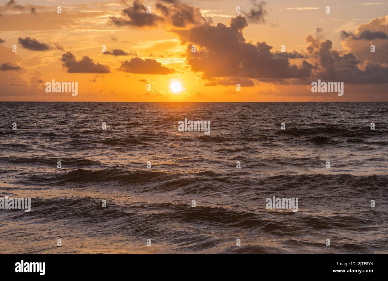 Goldene Wolken über dem Meer bei Sonnenaufgang Stockfoto