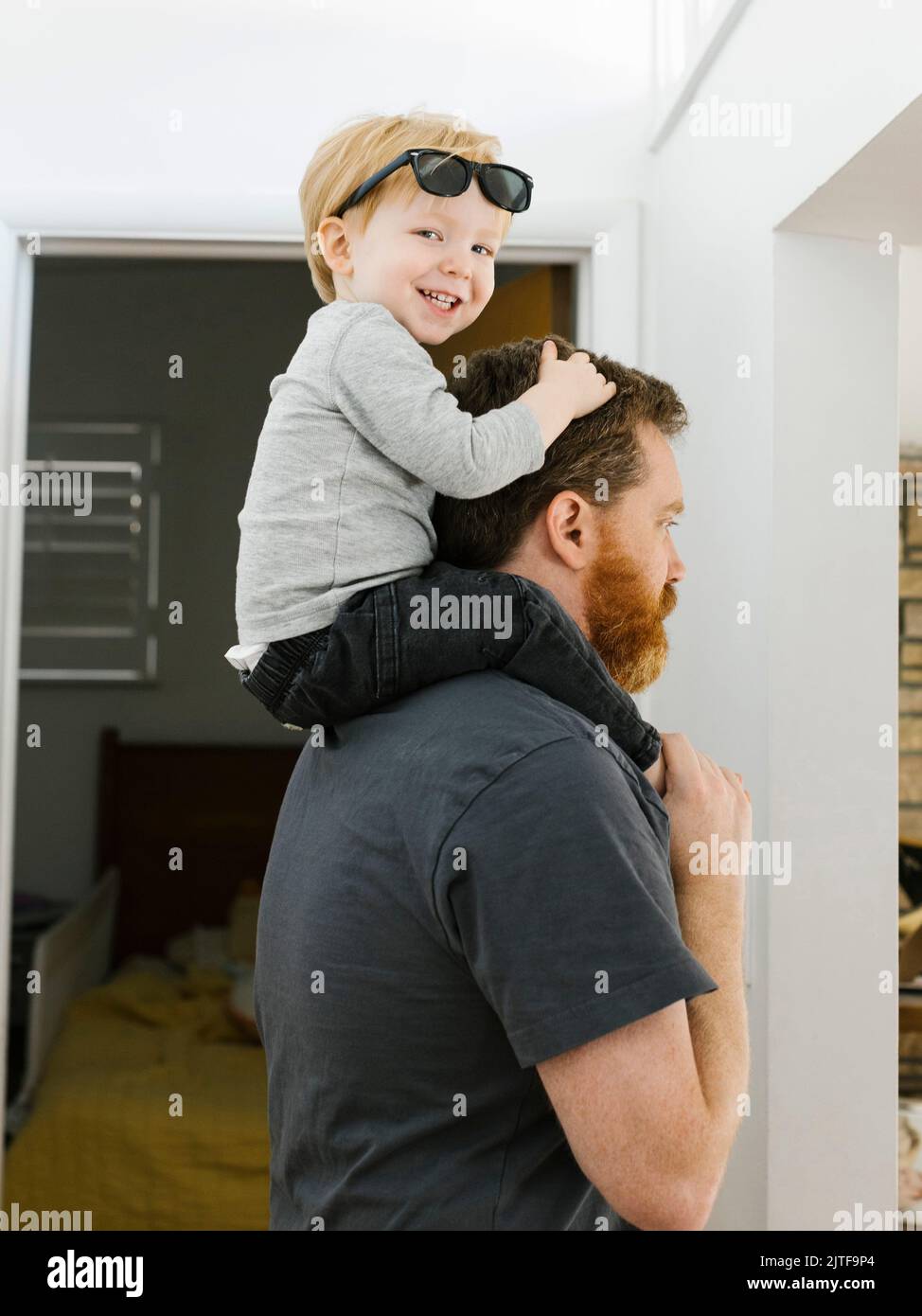 Vater trägt Sohn (2-3) zu Hause auf den Schultern Stockfoto